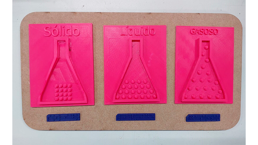 A imagem apresenta o recurso didático denominado Estado da Matéria, que é composto por 3 peças confeccionadas por impressão 3D, com sua respectiva identificação em braille. A identificação e as peças dos estados da matéria estão fixado numa placa de mdf.