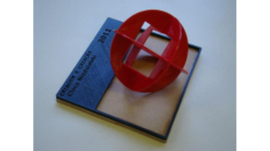 A imagem apresenta o recurso didático denominado Criador e Criação de Chico Niedzielski, e é composto por peças confeccionadas por impressão 3D e uma placa de MDF. Sobre a placa de MDF está a descrição da obra em braille. Apresenta a obra e compara a dimensão com uma peça plástica representado um homem em pé.